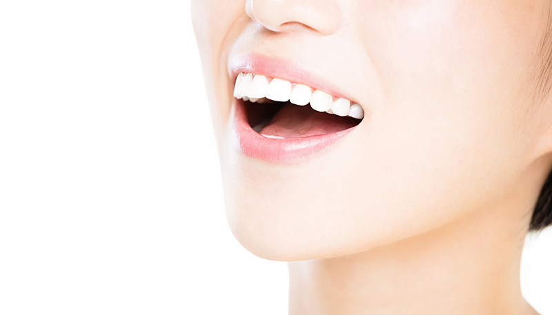 白く綺麗な歯を見せて笑っている様子