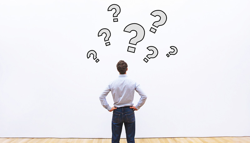 頭の上にはてなをたくさん出している男性の後ろ姿