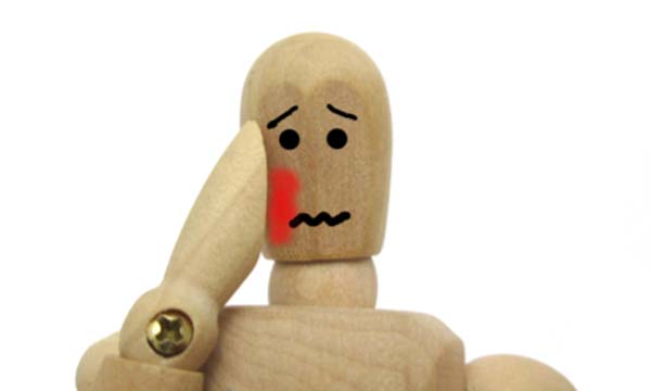 歯を痛めておさえる人形