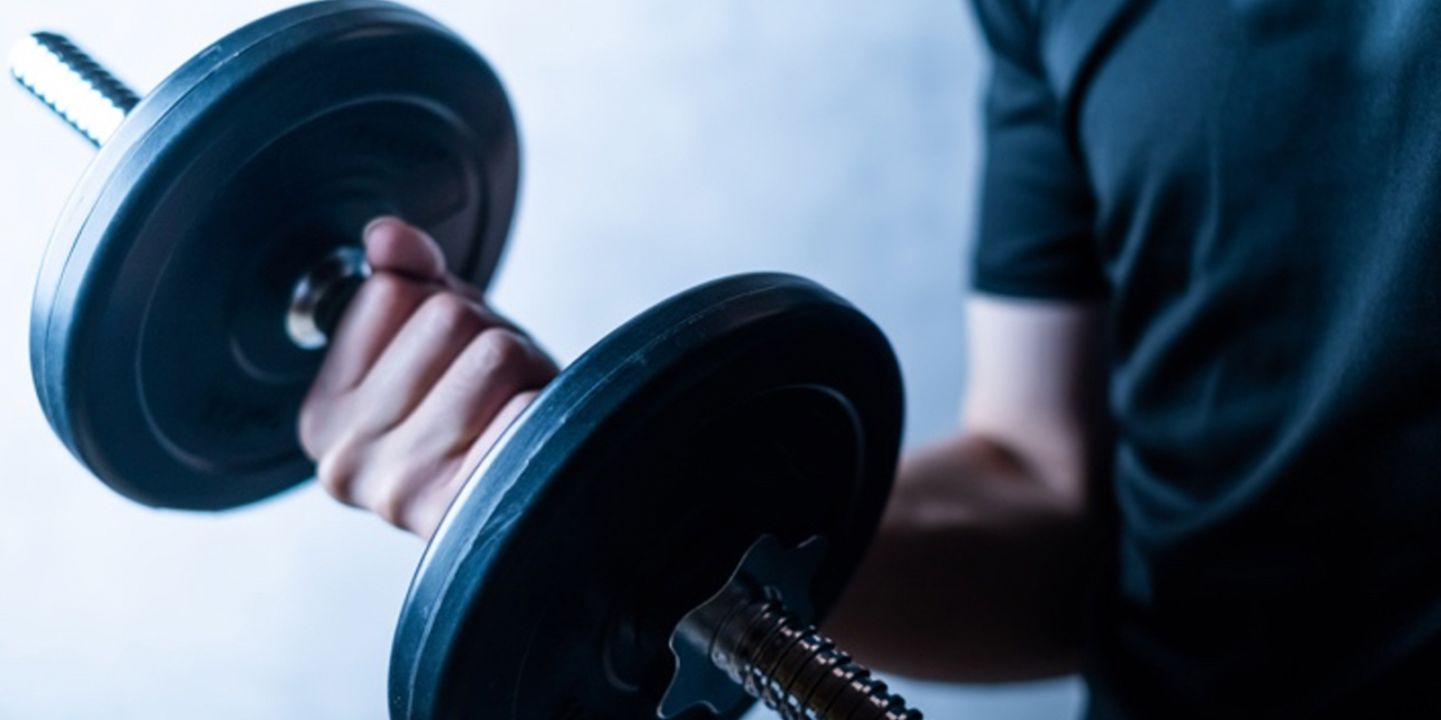 ダンベルで筋トレをする男性の腕