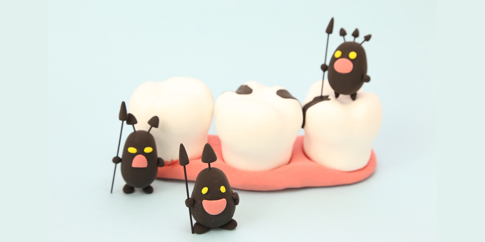 汚れた歯の模型に虫歯菌が集まっているイメージ
