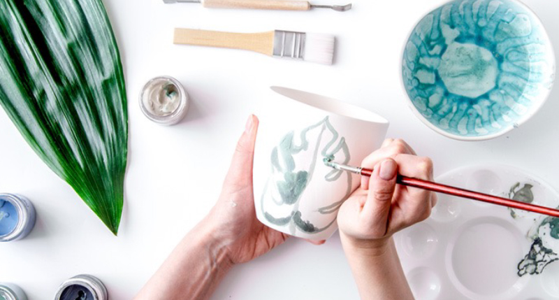 陶器のマグカップにイラストを描いている様子