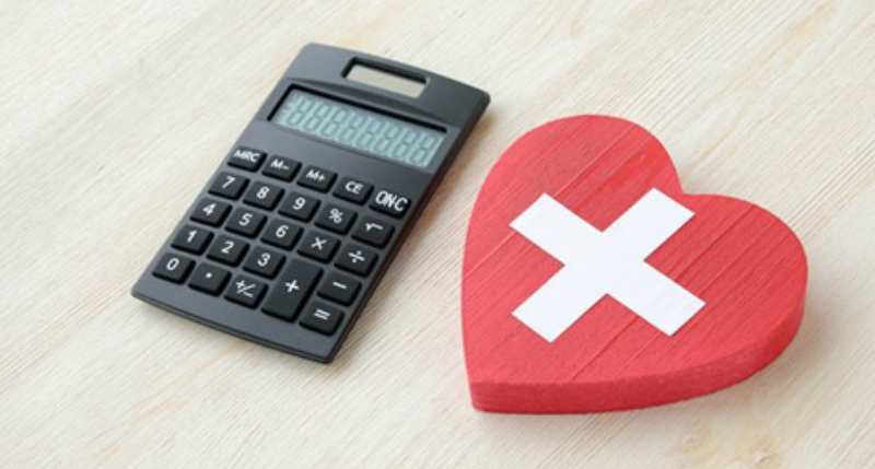 電卓と赤いハートに十字マークの書かれた物の写真