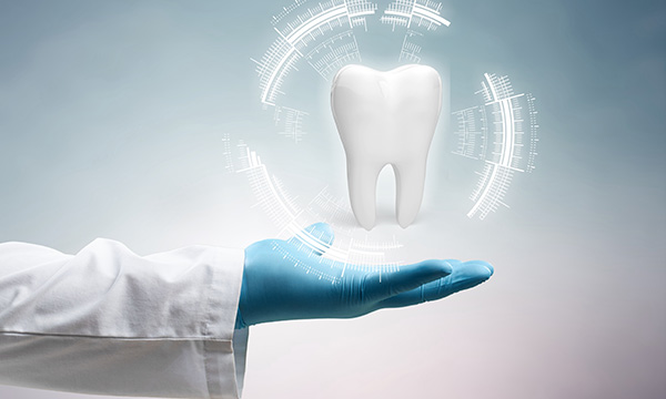 医師が手の平の上に真っ白で綺麗な歯を持っている画像