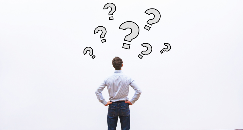 頭に上に？をたくさん出し悩んでいる後ろ姿の男性