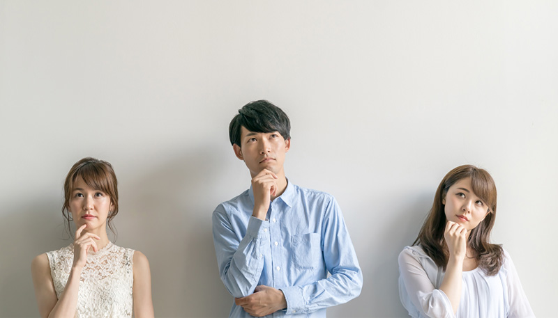 3人の男女が顎に手を添え考えている写真