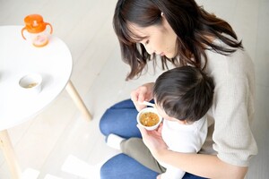 赤ちゃんに離乳食を与える女性の写真