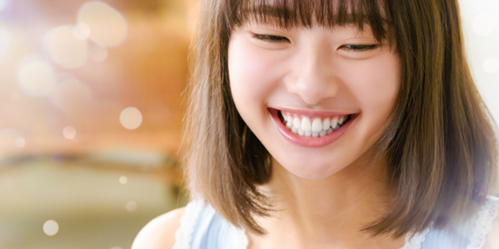 白く綺麗な歯を出し微笑む女性