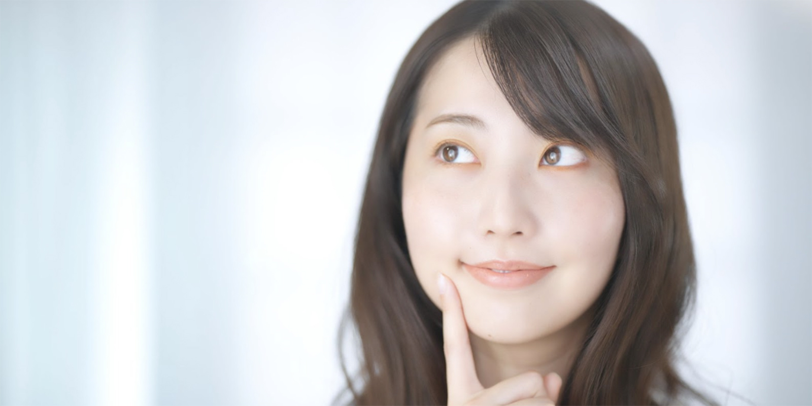 顎に指を当て微笑む助成