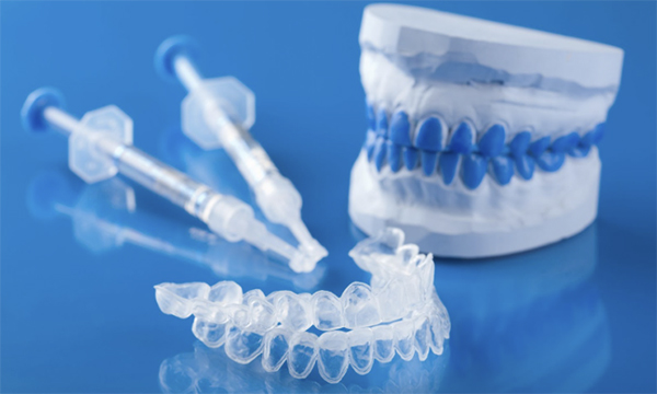 歯型の模型とホームホワイトニングジェル、ホームホワイトニングトレーの写真