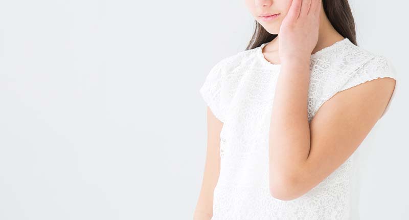 頬をおさえる女性