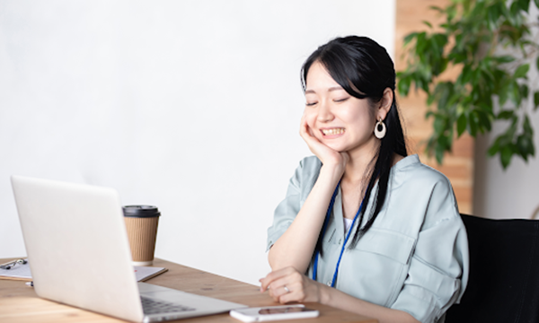 デスクワーク中にかみしめて顎を痛めている様子の女性