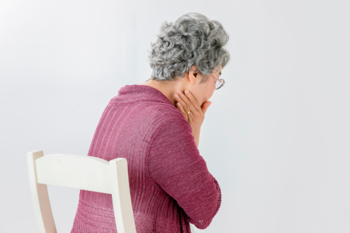 頬に手を当て痛がる老人の後ろ姿