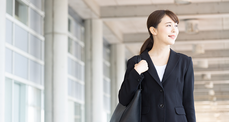 スーツ姿で歩く女性